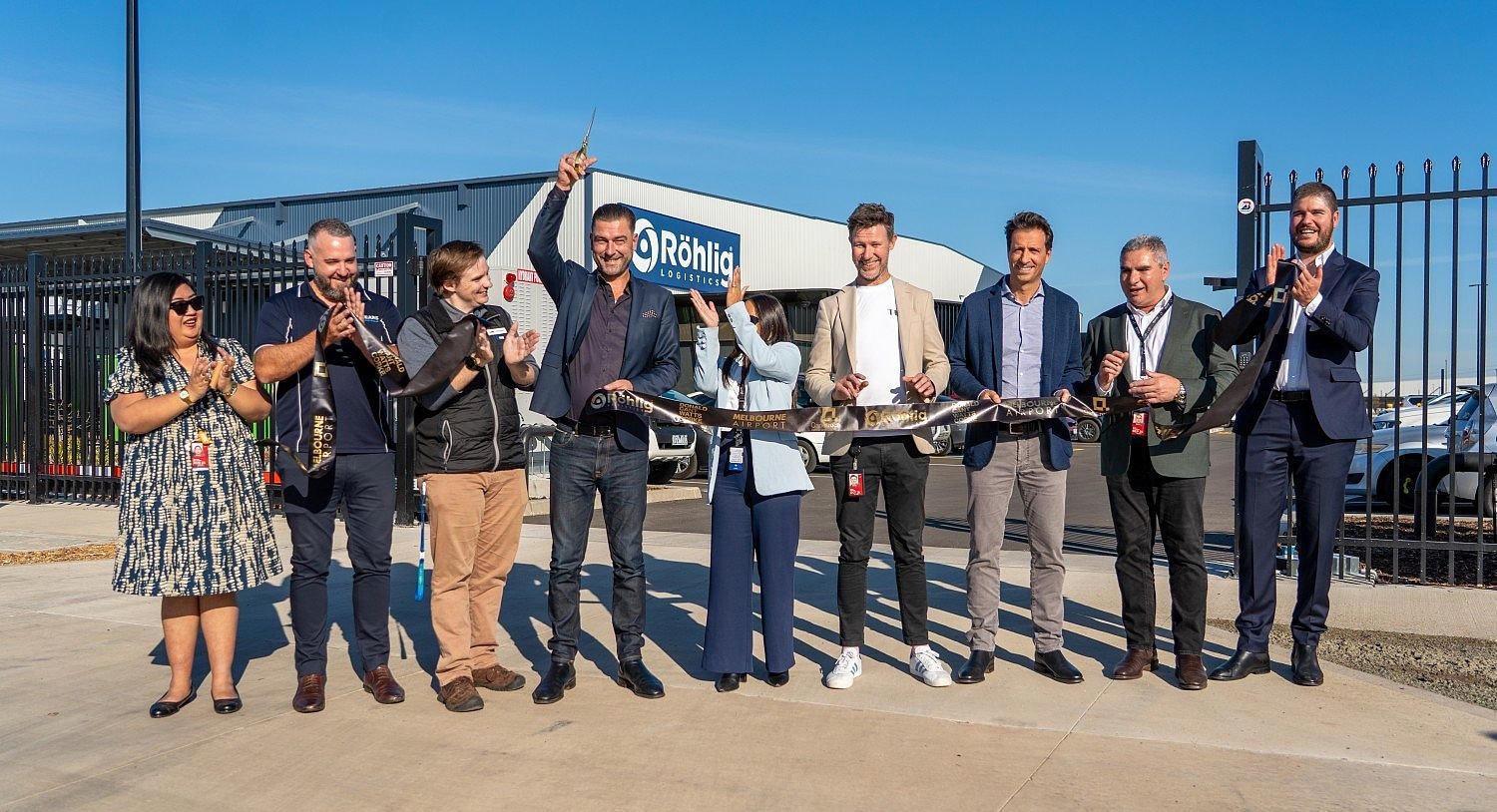 People standing in front of a just inaugurated warehouse cutting the cord