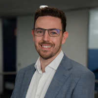 Portrait of an employee in the office Smiling employee wearing glasses in a grey blazer and white shirt in a modern office building