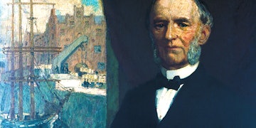 A Painting of Carl Röhlig in a suit with a bow tie standing in front of a Window. Through the Window you can sea the Harbor with a Ship, a Cran and Buildings.