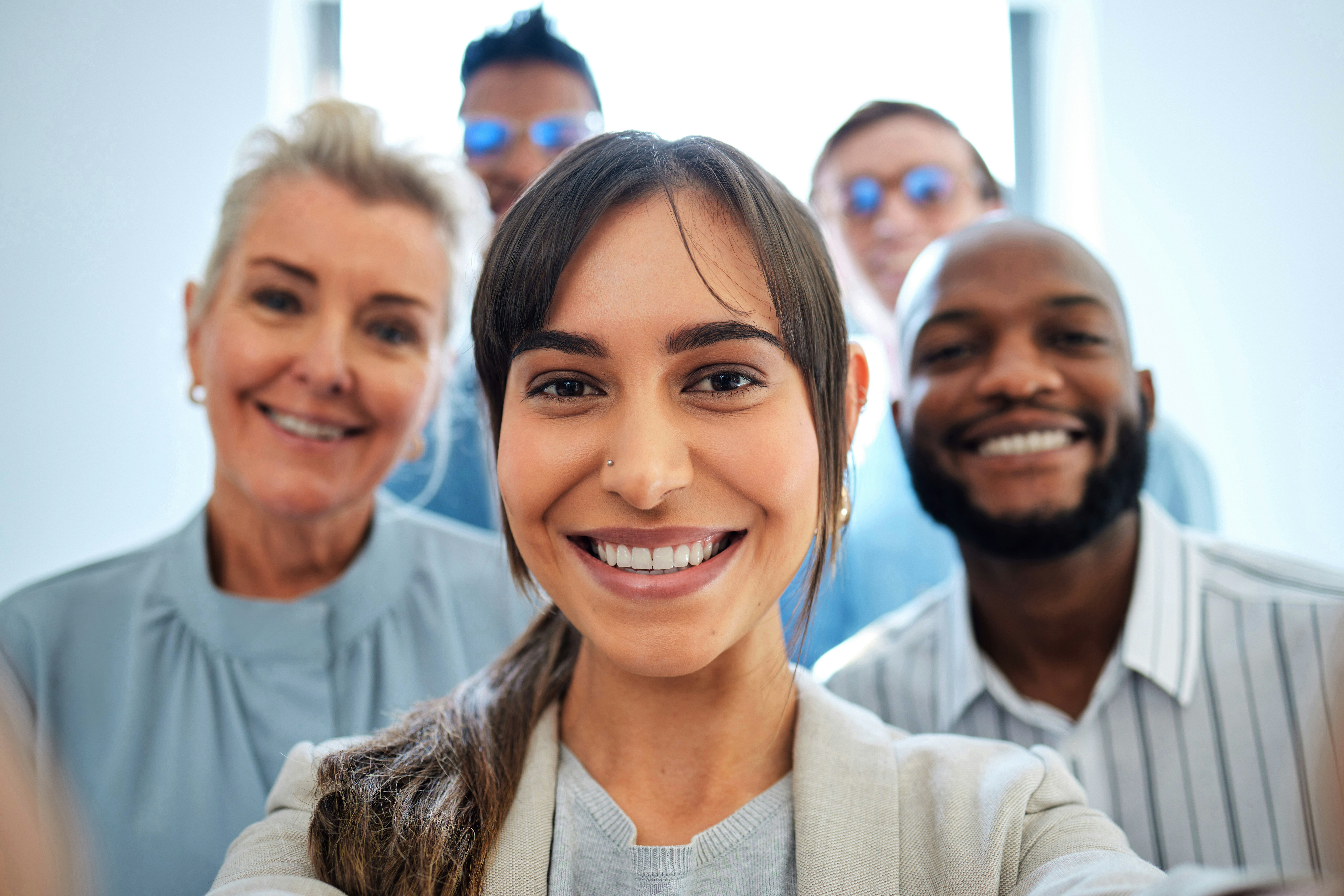 A group of five people are smiling in a camera. There are two women and three man.